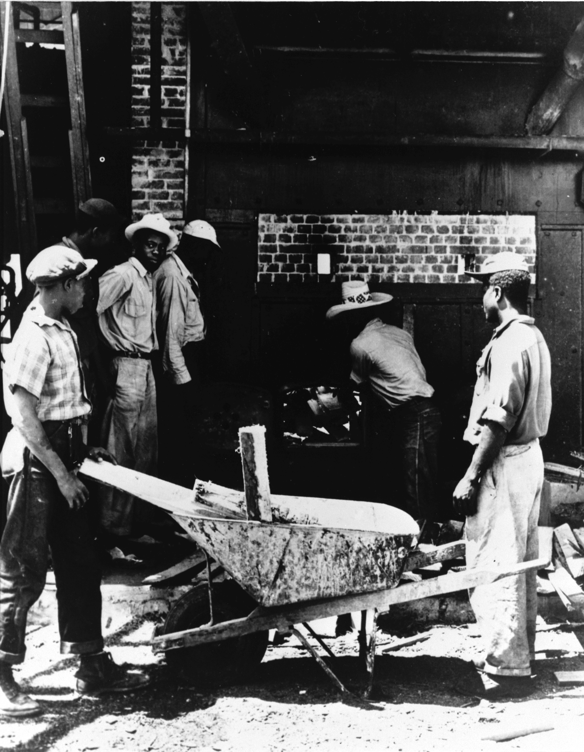 Stoking the firebox of steam turbine, Pine Ridge, 1940's